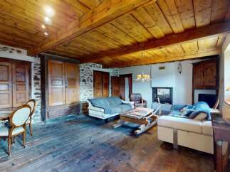 Experience rustic charm in this inviting living space featuring exposed wooden beams and a stone accent wall.