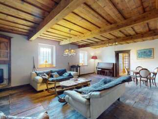 Experience rustic charm in this beautifully appointed living space, featuring exposed wooden beams and a cozy fireplace.
