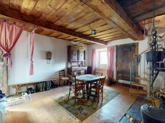 Step into this charming rustic dining area, featuring exposed wooden beams and a traditional hutch that adds character.