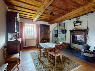 Step into a charming rustic dining area featuring a traditional wooden table set for four, perfect for intimate gatherings.