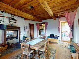 Experience rustic charm in this unique dining area, featuring exposed wooden beams and a cozy fireplace.