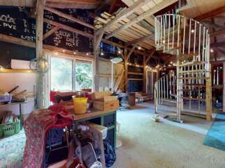 Discover this unique rustic barn conversion, featuring exposed wooden beams and a charming spiral staircase leading to an upper level.