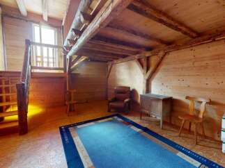 Discover this charming rustic interior featuring exposed wooden beams and warm wood paneling throughout.