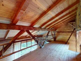 Experience rustic charm in this loft space, featuring exposed wooden beams and a natural wood finish throughout.