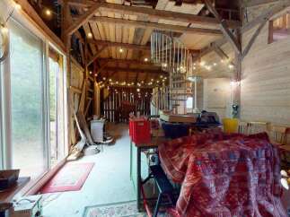 Step into this rustic barn conversion, featuring exposed wooden beams and charming string lights that create a warm ambiance.