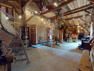 Discover this unique barn conversion featuring rustic wooden beams and a charming spiral staircase leading to an upper level.