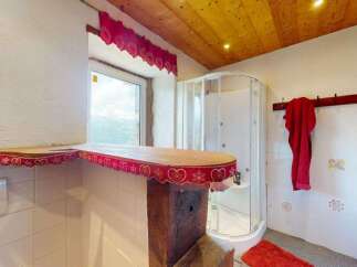Experience rustic charm in this bathroom featuring a wooden ceiling and a cozy shower stall.