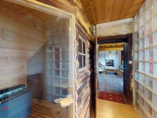 Experience ultimate relaxation in this unique sauna room, featuring natural wood paneling and a modern electric heater.