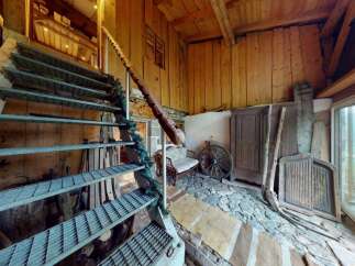 Discover rustic charm in this unique property featuring a striking metal staircase leading to upper levels.