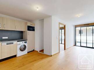 Discover this modern apartment featuring a sleek, integrated kitchen with ample cabinet space and a built-in microwave.