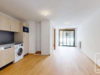 Discover this modern apartment featuring a sleek, integrated kitchen with a microwave and ample cabinet space.
