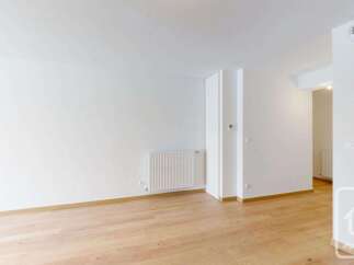 This spacious room features a modern white radiator and a clean, minimalist design.