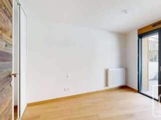 Experience modern living in this bright and airy room, featuring a striking wooden accent wall and a sleek white door.