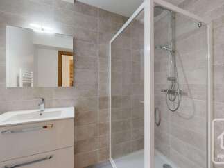This modern bathroom features a sleek vanity with a large mirror and integrated lighting, perfect for your morning routine.