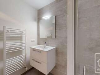 This modern bathroom features a sleek vanity with ample storage and a stylish chrome faucet.