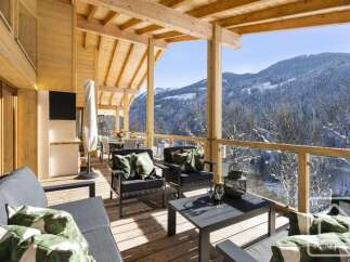 Experience breathtaking mountain views from this stunning wooden balcony, perfect for enjoying your morning coffee or evening wine.