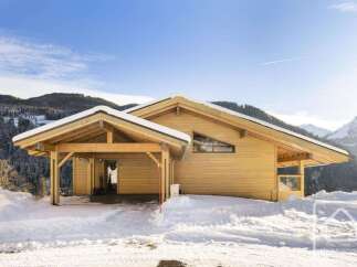 Experience luxury mountain living in this stunning wooden chalet, perfectly situated amidst snow-covered landscapes and majestic peaks.