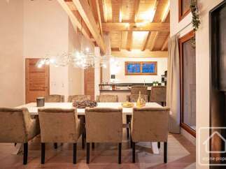 Experience elegant dining in this beautifully appointed space, featuring a large wooden table surrounded by plush, upholstered chairs.