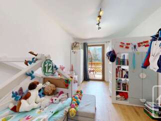 This charming children's bedroom features a playful loft bed adorned with stuffed animals and decorative elements.