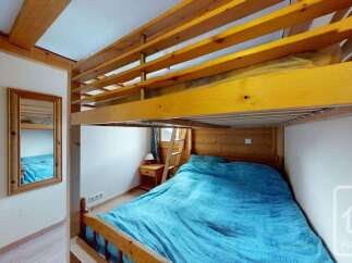 Discover this charming bedroom featuring a cozy bunk bed with a vibrant blue comforter, perfect for maximizing space.