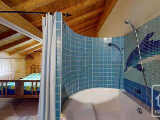 Experience rustic charm and modern comfort in this unique property, featuring exposed wooden beams and a cozy bedroom.
