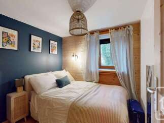 This charming bedroom features a cozy bed adorned with crisp white linens and a striped throw blanket, perfect for a relaxing retreat.