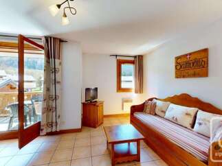 This charming living area features a comfortable wooden daybed adorned with decorative pillows, perfect for relaxing after a day of skiing.