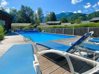Enjoy a refreshing dip in this stunning outdoor swimming pool, surrounded by a spacious wooden deck perfect for sunbathing.