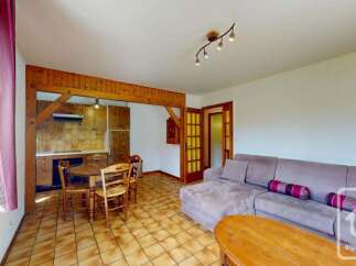 This charming living space features a cozy dining area with a wooden table and chairs, perfect for intimate meals.