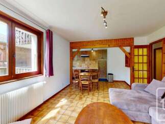 This charming living area features a cozy dining nook with a wooden table and chairs, perfect for intimate meals.