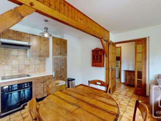 This charming kitchen features rustic wooden cabinetry and a tiled backsplash, creating a warm and inviting atmosphere.
