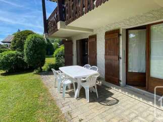 Enjoy outdoor living with this charming patio featuring a white table and chairs, perfect for al fresco dining.