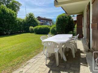 Enjoy outdoor dining and relaxation on this charming patio, complete with a white table and chairs.