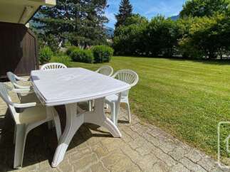 Enjoy outdoor dining on this charming patio, complete with a white plastic table and chairs.