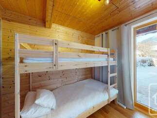 Experience cozy mountain living in this charming wooden cabin featuring a space-saving bunk bed perfect for families or groups.