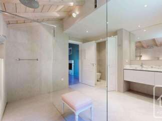 Experience luxury in this spacious bathroom featuring a walk-in shower with a rainfall showerhead and a handheld wand.