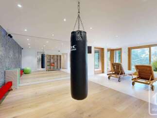 This spacious home gym features a professional-grade punching bag, a large mirror for workouts, and a yoga ball.