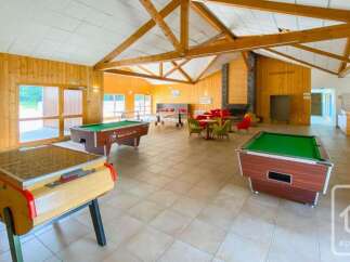 This spacious recreational room features multiple entertainment options, including two pool tables and a foosball table, perfect for family fun or group gatherings.