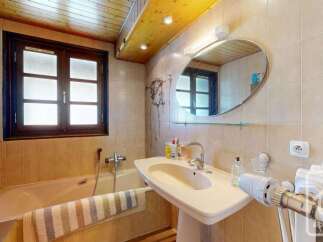 This charming bathroom features a classic bathtub and a pedestal sink, perfect for a relaxing soak or a quick refresh.