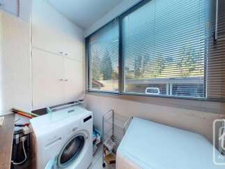 This laundry room features a white washing machine and a white dryer, perfect for handling your household chores.
