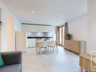This modern apartment features a bright and airy open-plan living space, seamlessly integrating a contemporary kitchen with a dining area.