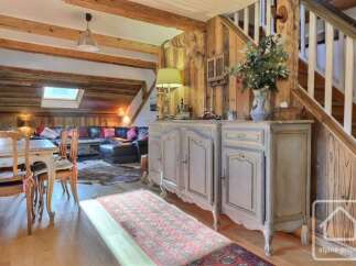 Experience rustic charm in this spacious living area, featuring exposed wooden beams and a cozy fireplace.