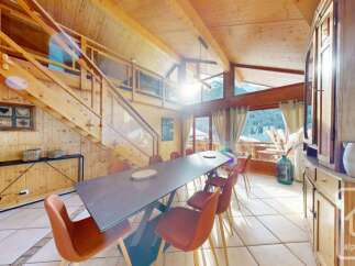 Experience luxurious mountain living in this stunning chalet featuring a spacious dining area with a large wooden table and comfortable seating, perfect for family gatherings.