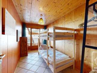 This charming alpine bedroom features a cozy bunk bed, perfect for accommodating guests or children.