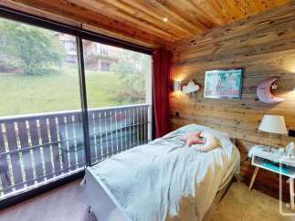Experience cozy mountain living in this charming bedroom featuring warm wooden walls and a ceiling.