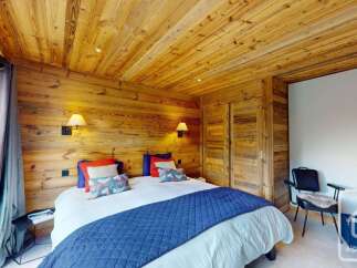 Experience rustic charm in this cozy bedroom featuring warm, wood-paneled walls and ceiling.