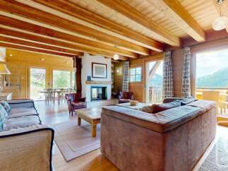 Experience rustic charm and breathtaking mountain views in this stunning chalet living room.