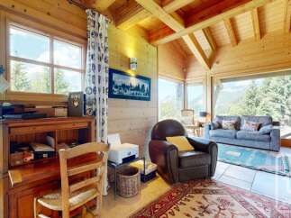 Experience cozy living in this charming wooden cabin, featuring a rustic desk area perfect for work or study.