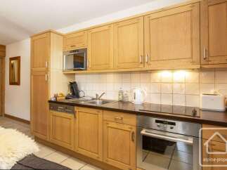This charming kitchen features light wood cabinetry, offering ample storage space and a warm, inviting atmosphere.