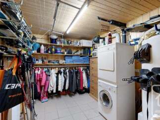 This spacious storage area is perfect for outdoor enthusiasts, featuring ample shelving for gear and a dedicated rack for skis and snowboards.